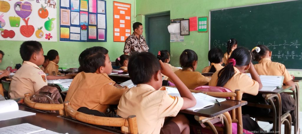 Guru Indonesia mengajar teacher teaching student in classroom